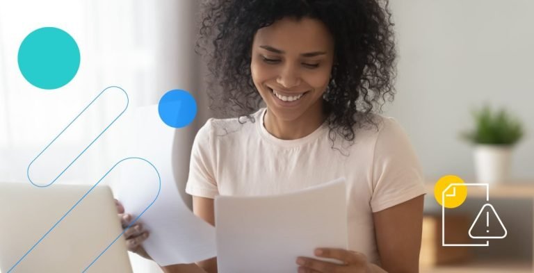 Mulher segurando documentos em frente a computador