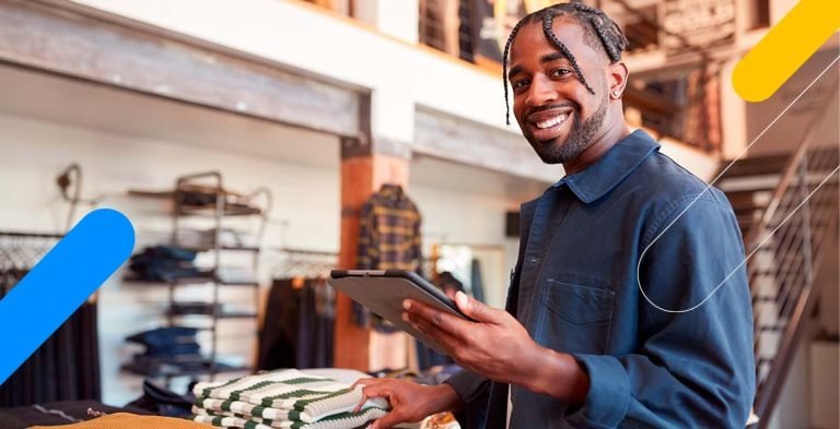 Homem segurando tablet e sorrindo em loja