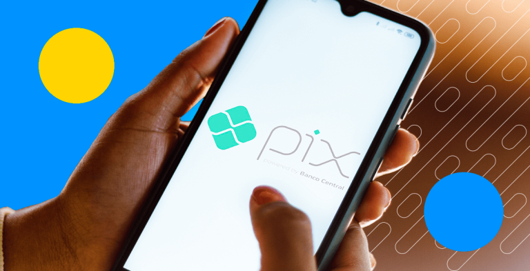 Mão segurando celular com tela mostrando logo do Pix
