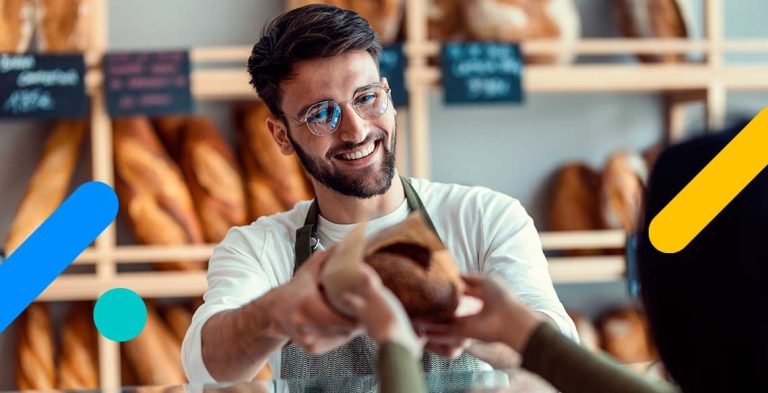 Homem sorrindo oferecendo pão a outra pessoa