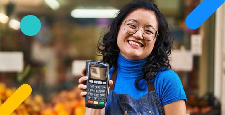 Mulher sorrindo segurando maquininha de cartão